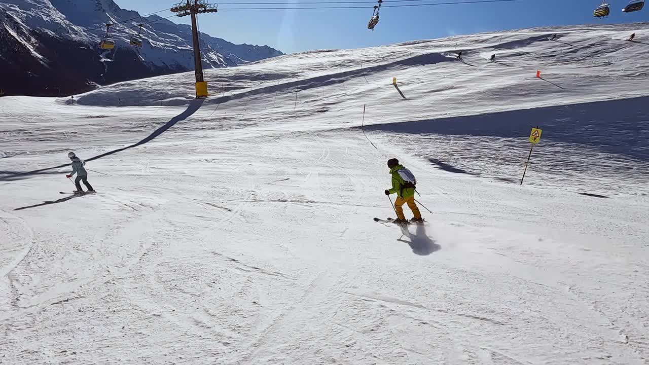 一个年轻人在阿尔卑斯山的滑雪坡上滑雪下坡视频素材