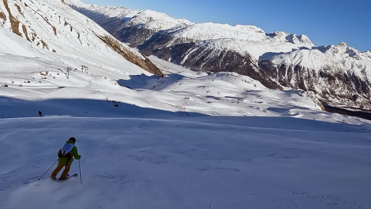 一个年轻人在阿尔卑斯山的滑雪坡上滑雪下坡视频素材