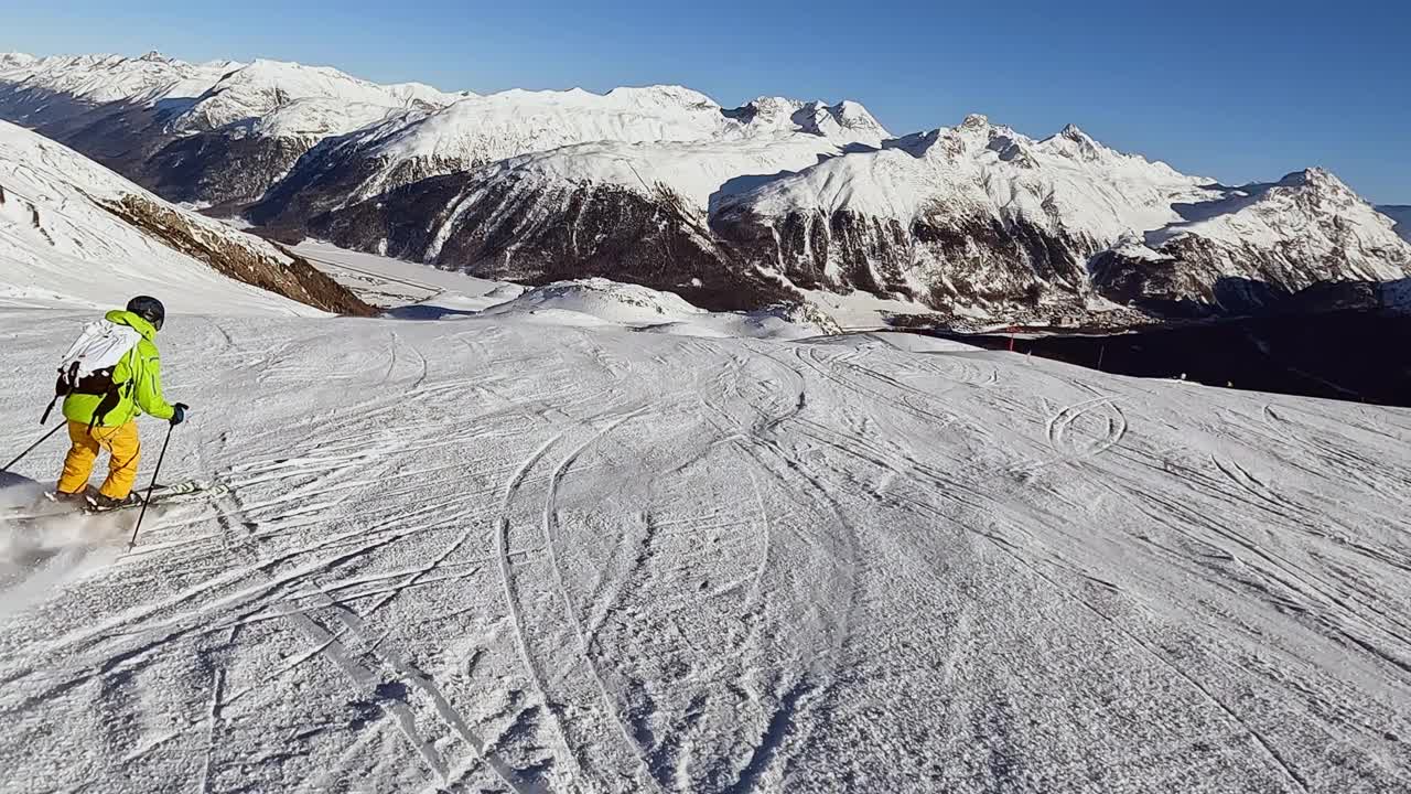 一个年轻人在阿尔卑斯山的滑雪坡上滑雪下坡视频素材