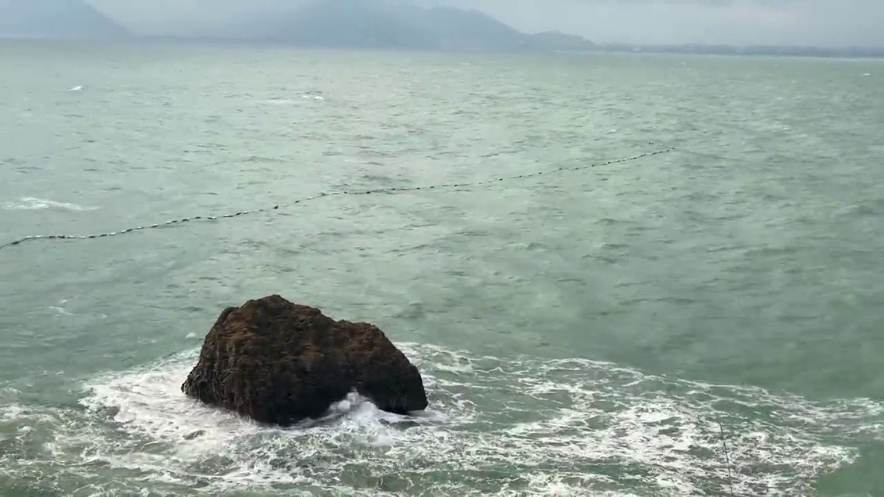 这是一个小岛在波涛汹涌的大海中央的视频。视频素材