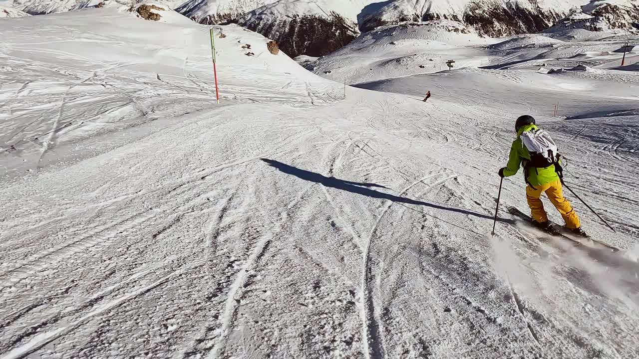 一个年轻人在阿尔卑斯山的滑雪坡上滑雪下坡视频素材