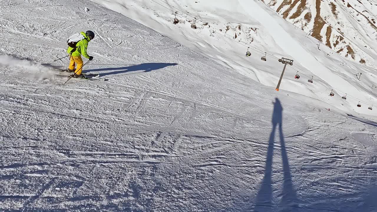 一个年轻人在阿尔卑斯山的滑雪坡上滑雪下坡视频素材