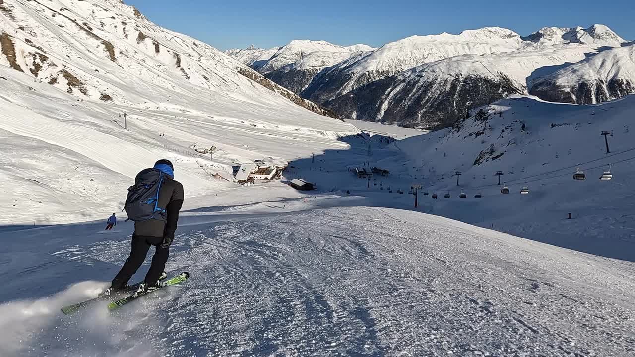 一个年轻人在阿尔卑斯山的滑雪坡上滑雪下坡视频素材