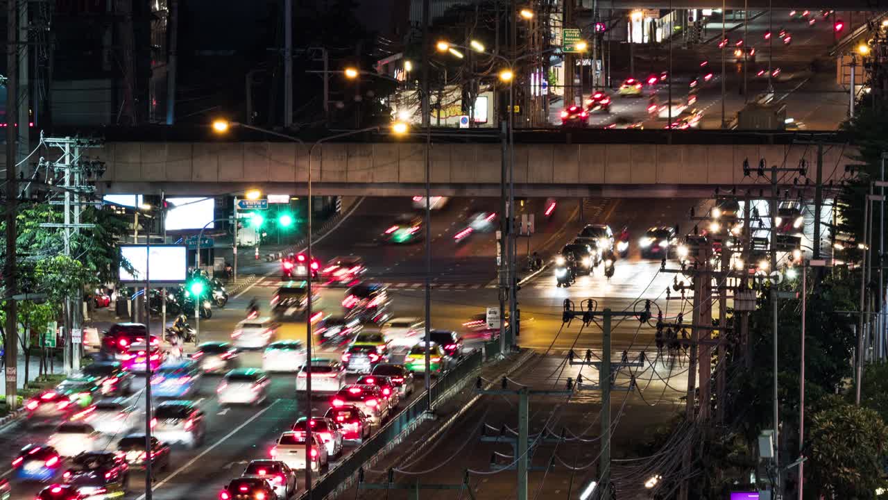 亚洲城市交叉口道路上汽车交通的延时，夜景高视角。公共交通，亚洲城市生活，通勤生活理念视频素材