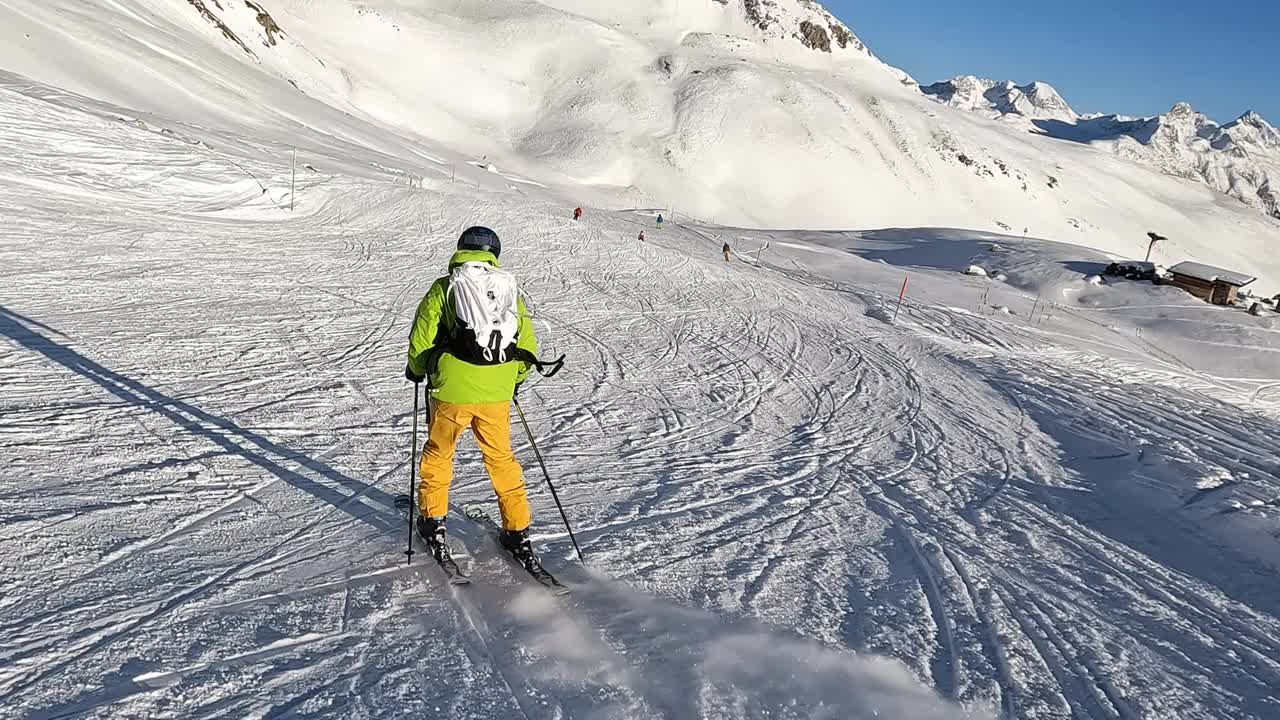 一个年轻人在阿尔卑斯山的滑雪坡上滑雪下坡视频素材