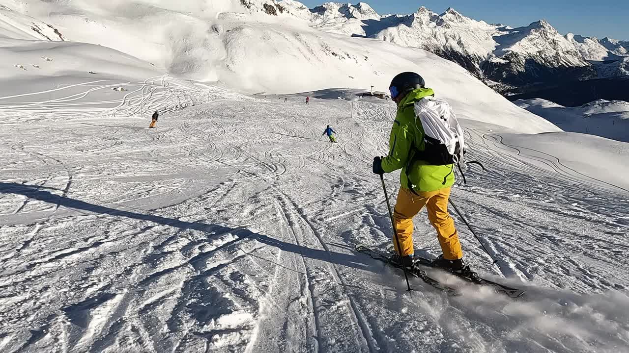 一个年轻人在阿尔卑斯山的滑雪坡上滑雪下坡视频素材