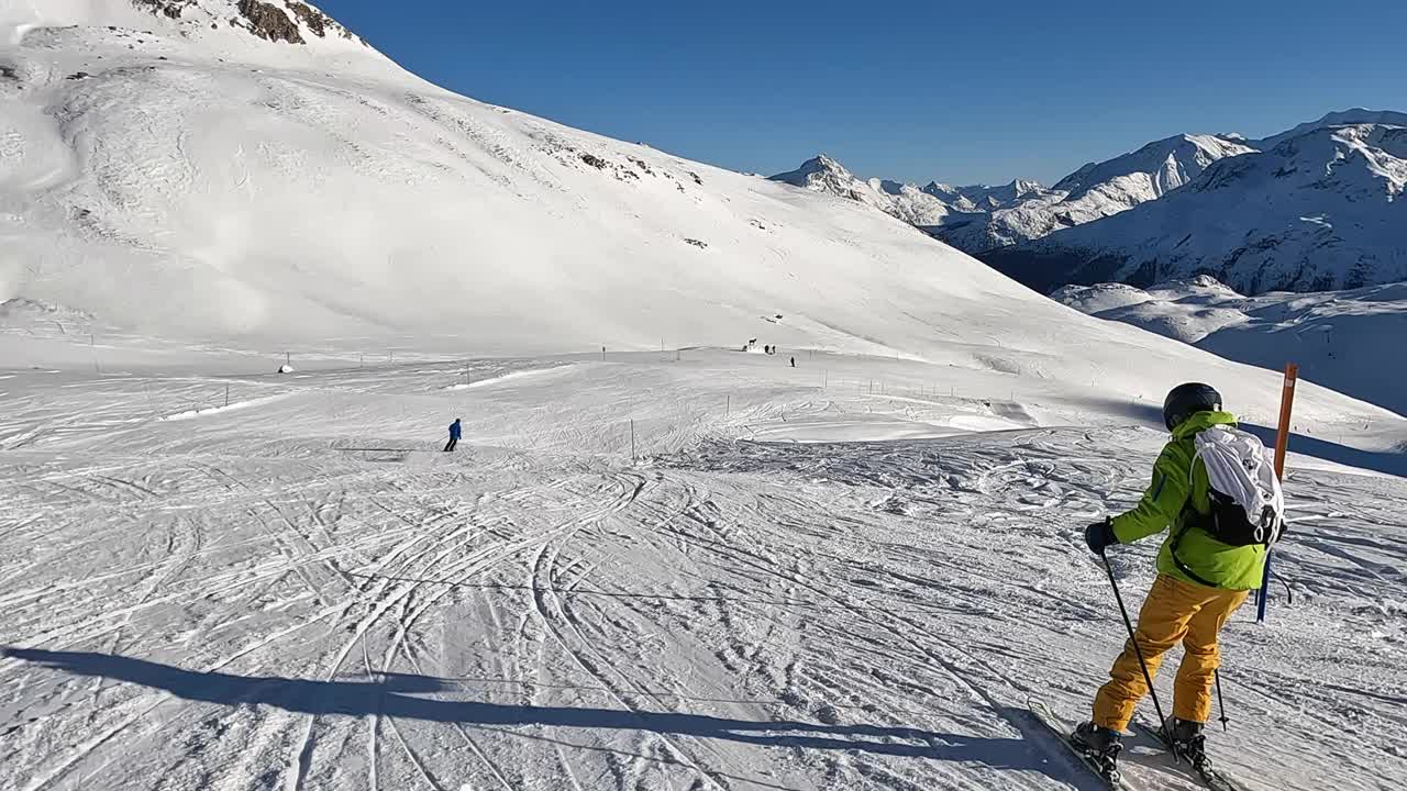 一个年轻人在阿尔卑斯山的滑雪坡上滑雪下坡视频素材