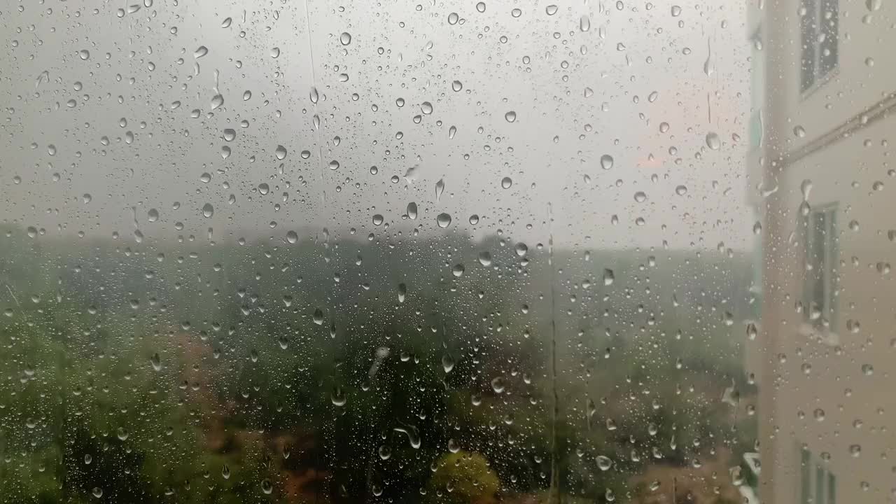 雨点落在窗户上，在一个暴风雨般的寒冷的冬天。4 k视频视频素材