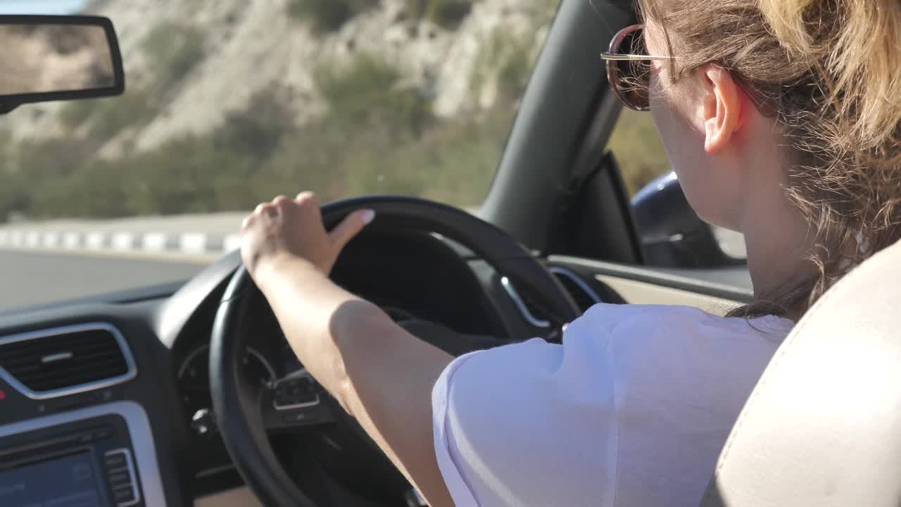 年轻女子驾驶敞篷车在乡村道路内后视图视频素材