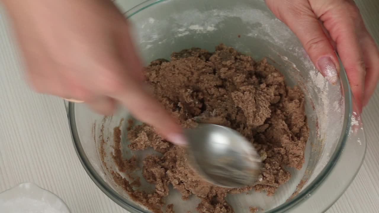 用勺子搅拌姜饼面团的女人。制作雪花和星星形状的姜饼。特写镜头。视频素材