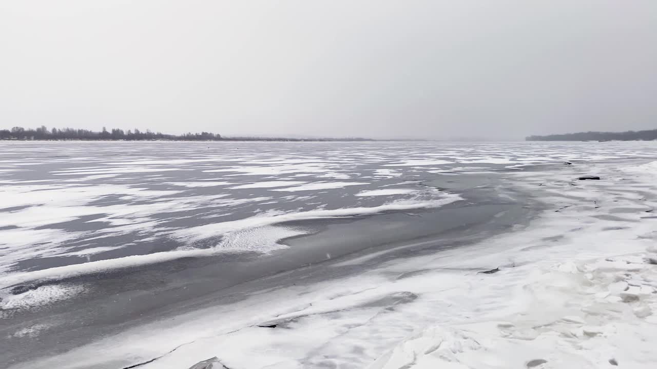 雪河冬季景观。河边结冰的冰雪。春天使水面上的冰融化了。视频素材