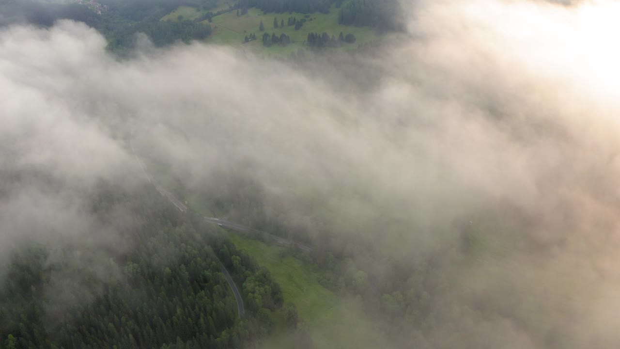 空中前进田园诗般的拍摄在风景上的绿色森林，无人机飞行在白云上向前-图林根，德国视频素材