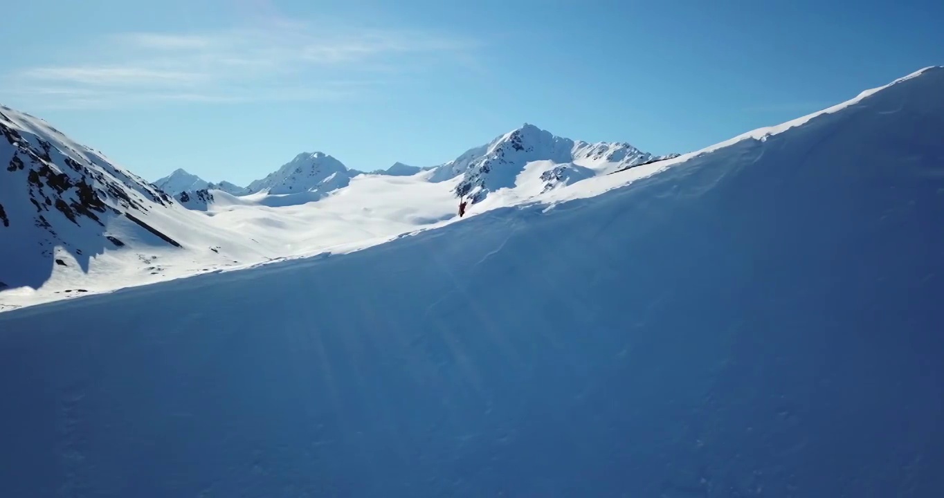 空中向前拍摄的人徒步与滑雪杆在岩层，无人机飞行在雪-内部阿拉斯加，阿拉斯加视频素材