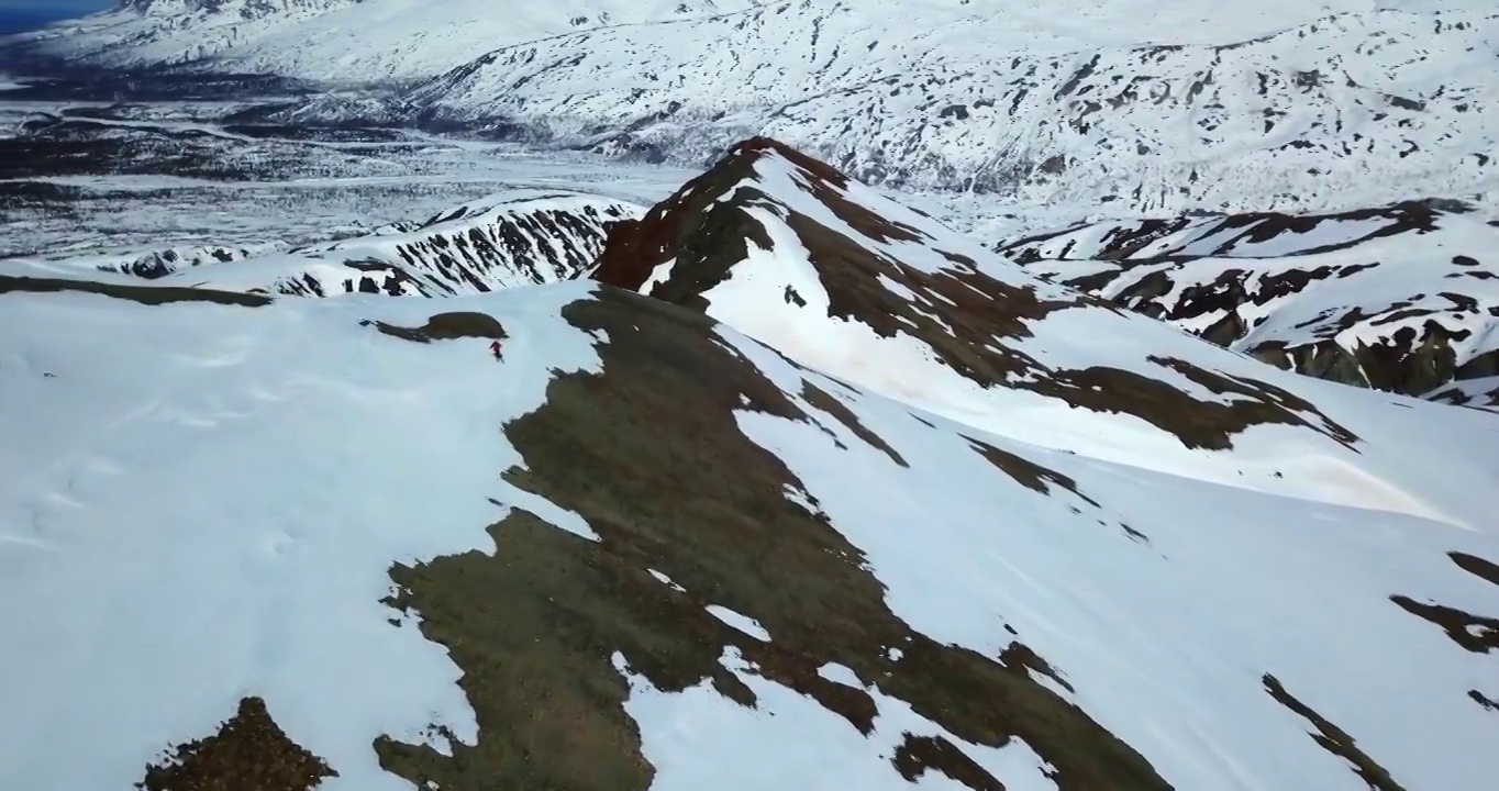 空中向前平移拍摄的人滑雪在雪山，无人机下降在阳光明媚的一天-内部阿拉斯加，阿拉斯加视频素材