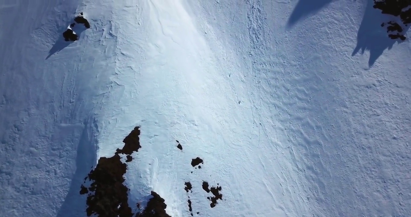 空中顶部向前拍摄的人在岩石上滑雪，无人机飞行在白色的雪上向前-内部阿拉斯加，阿拉斯加视频素材