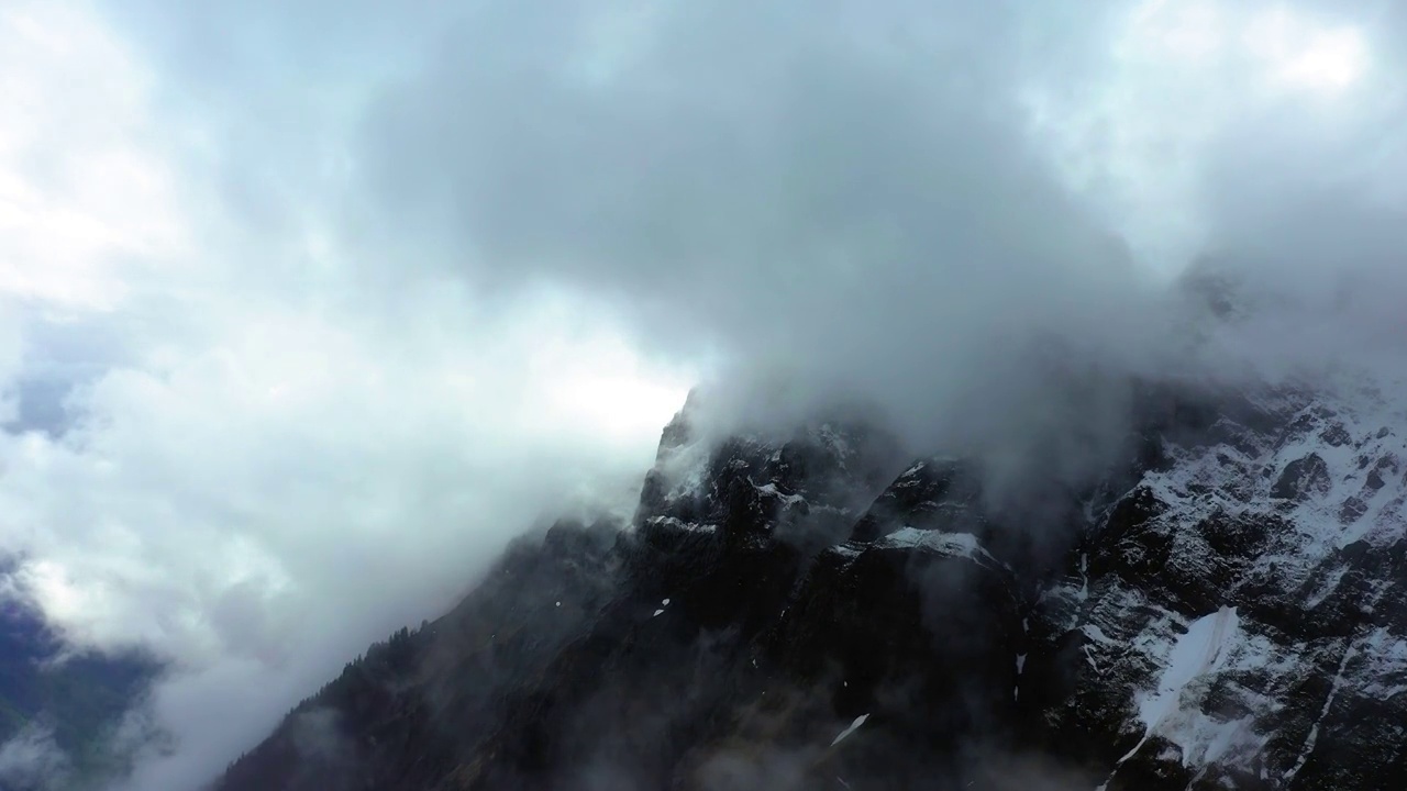 无人机在白云中向前飞行的雪覆盖岩层的空中风景-法国萨瓦视频素材