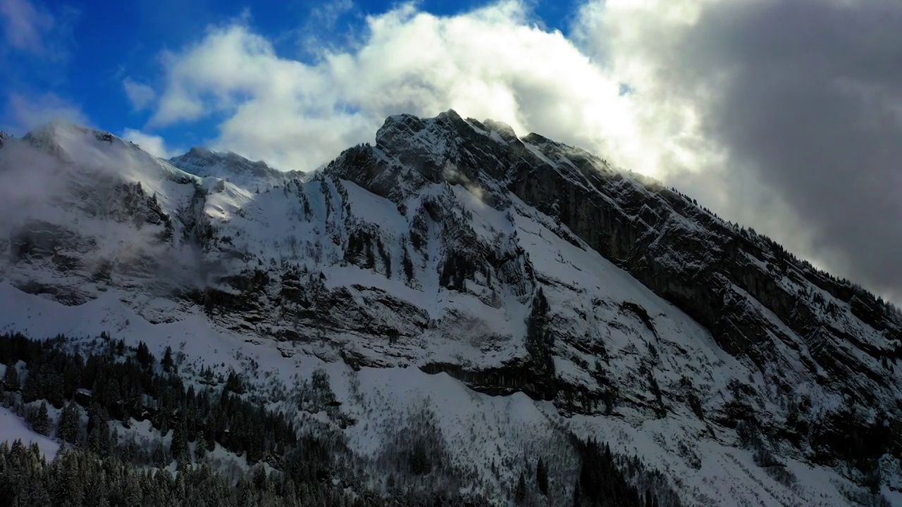 空中美丽的镜头，在雪山上的森林对多云的天空-萨瓦，法国视频素材