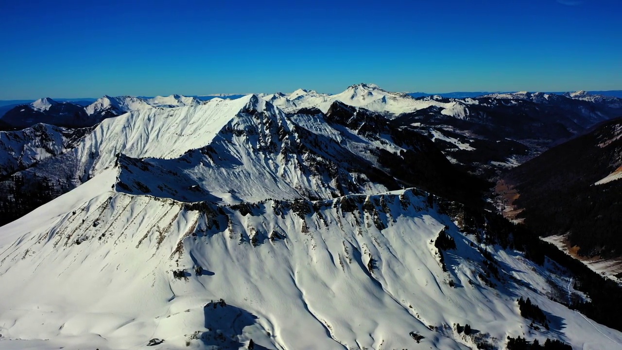 在阳光明媚的日子里，空中俯瞰冰雪覆盖的岩层——法国萨瓦视频素材