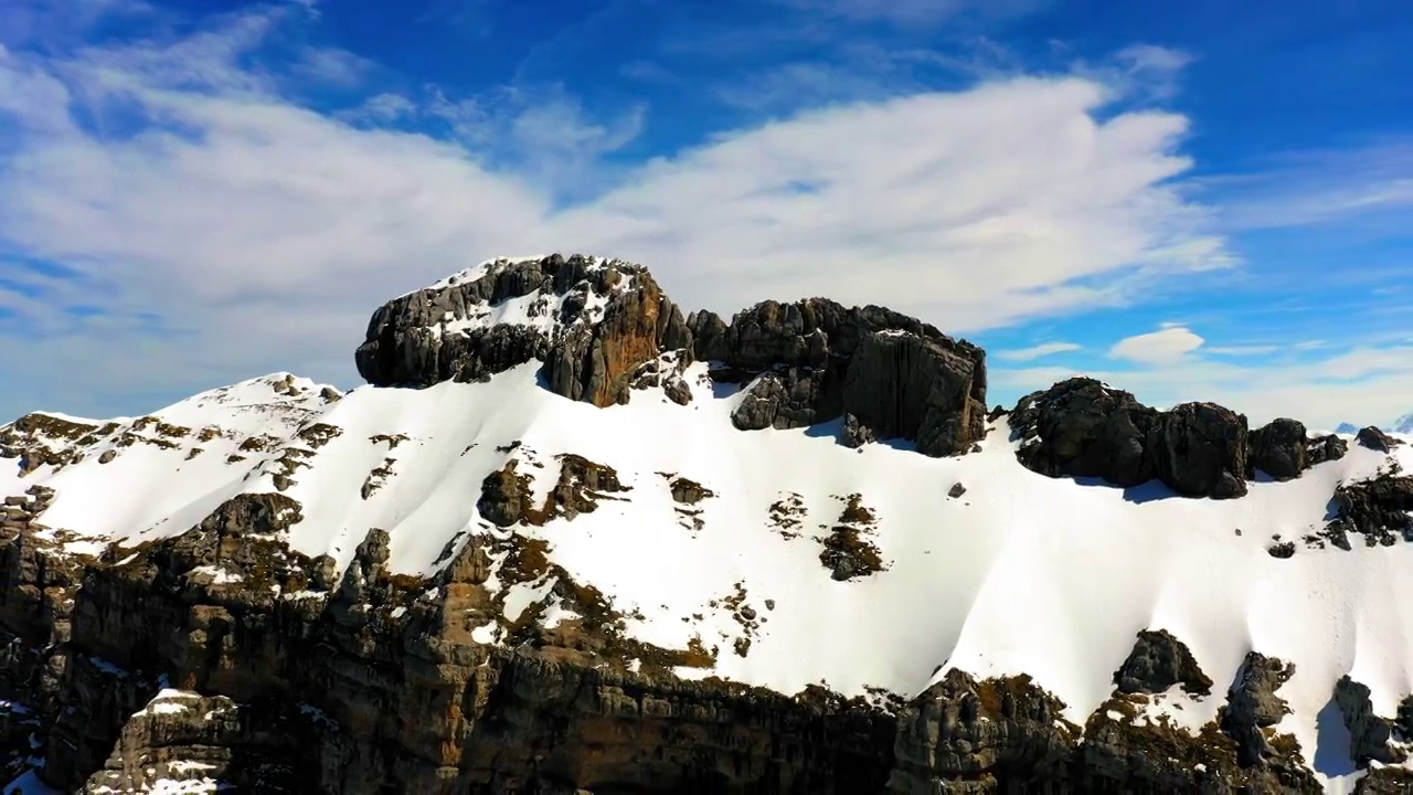 空中向后看美丽的雪山岩层，无人机飞行在阳光明媚的一天-萨瓦，法国视频素材