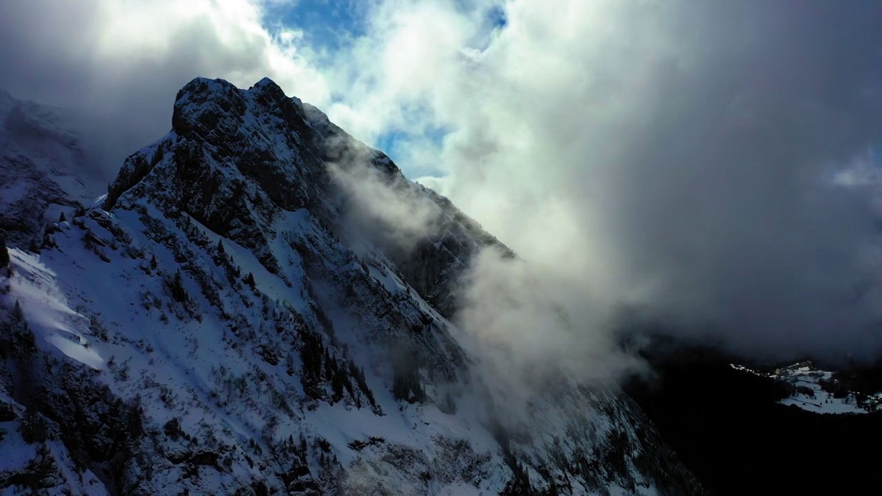 空中风景的树木，在积雪覆盖的山上对抗多云的天空-萨瓦，法国视频素材