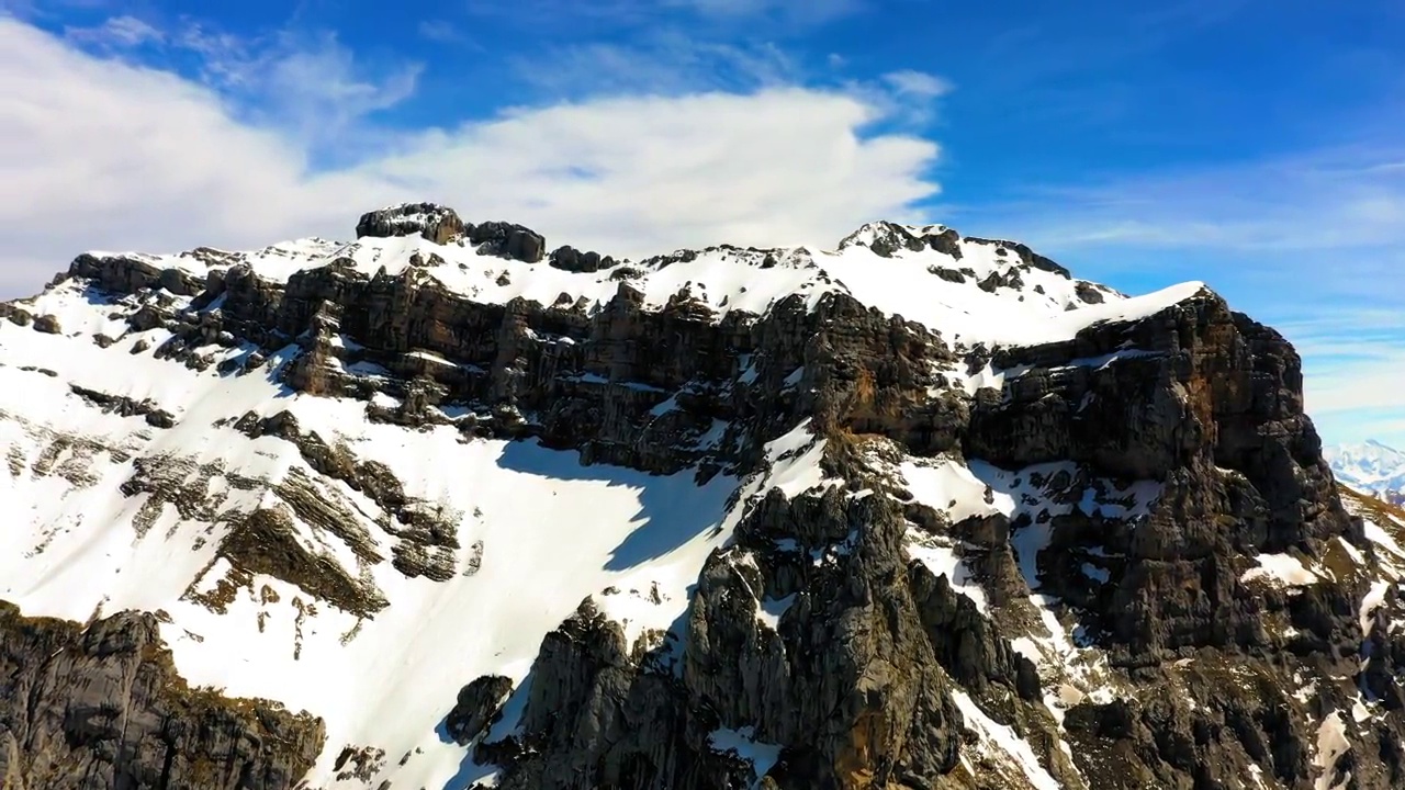 在阳光明媚的日子里，空中的雪山岩层与多云的天空相映衬——法国萨瓦视频素材