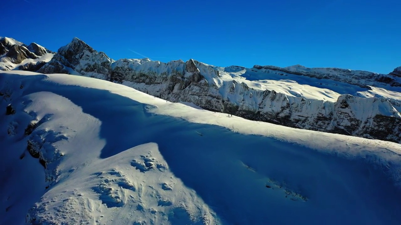 航拍的人们在寒假期间探索雪山山顶-法国萨瓦视频素材