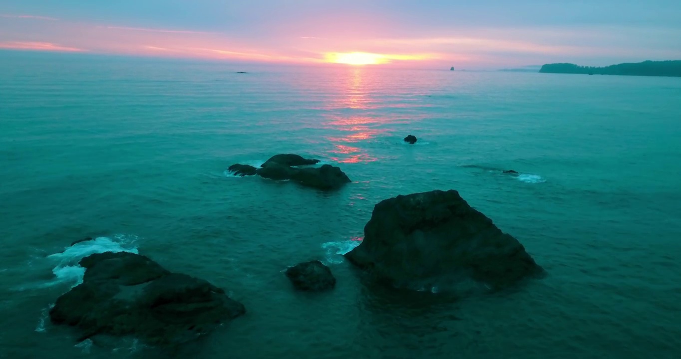 空中下降美丽的镜头，在海上的岩石与天空日落-红宝石海滩，华盛顿视频素材