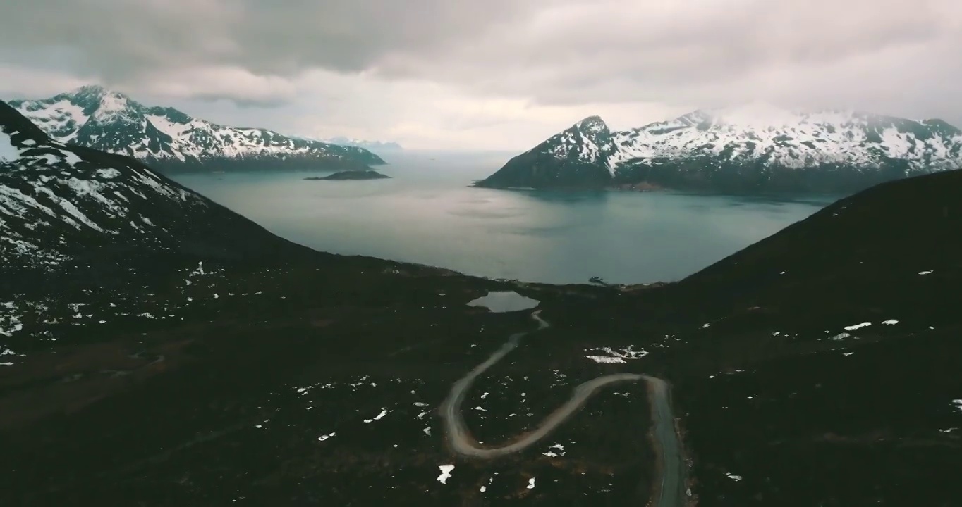 空中倾斜拍摄的雪山在海上，无人机飞越景观-特罗姆瑟市，挪威视频素材