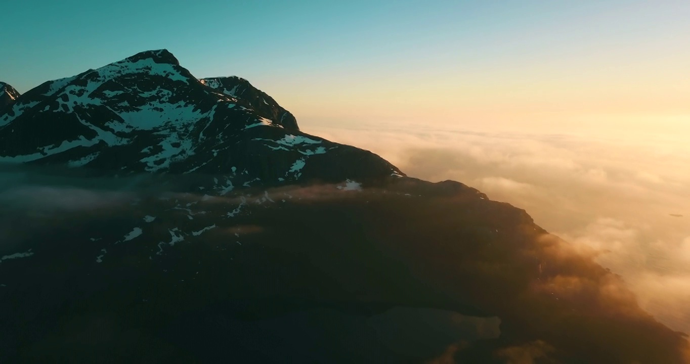 空中向后拍摄的雪的自然岩层在日落，云移动在景观在冬季-特罗姆瑟市，挪威视频素材