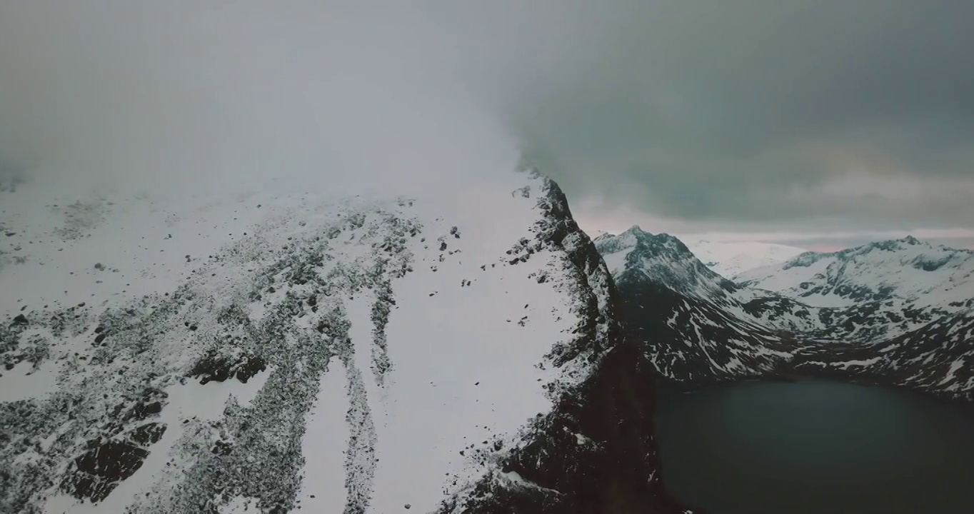 空中风景拍摄的海在雪山对白色多云的天空-特罗姆瑟市，挪威视频素材