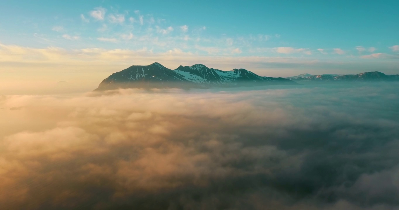 空中风景拍摄的雪的岩石在日落，无人机飞行在白色的云在冬季-特罗姆瑟市，挪威视频素材