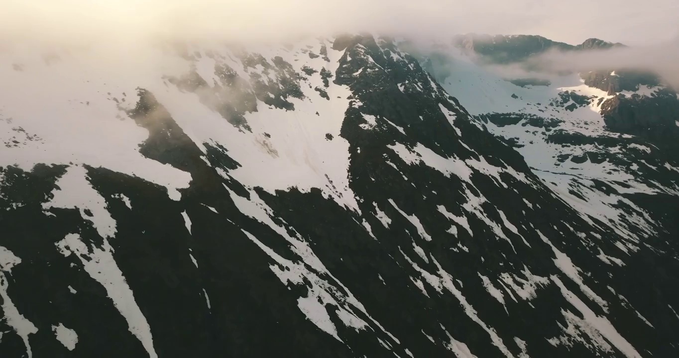 空中前进风景拍摄的云移动在冬天的雪山在海上-特罗姆瑟市，挪威视频素材