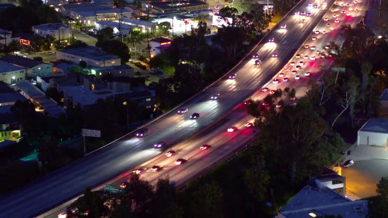 空中向后拍摄的照亮的汽车在城市的桥梁道路上移动-卡尔弗市，加利福尼亚州视频素材