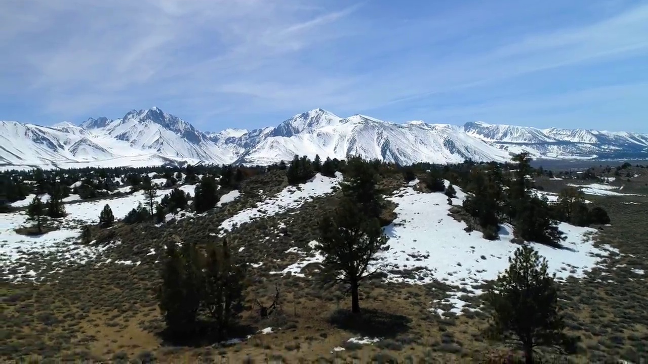 自然山脉的空中宁静景象，无人机向后飞行在雪景-猛犸湖，加利福尼亚视频素材