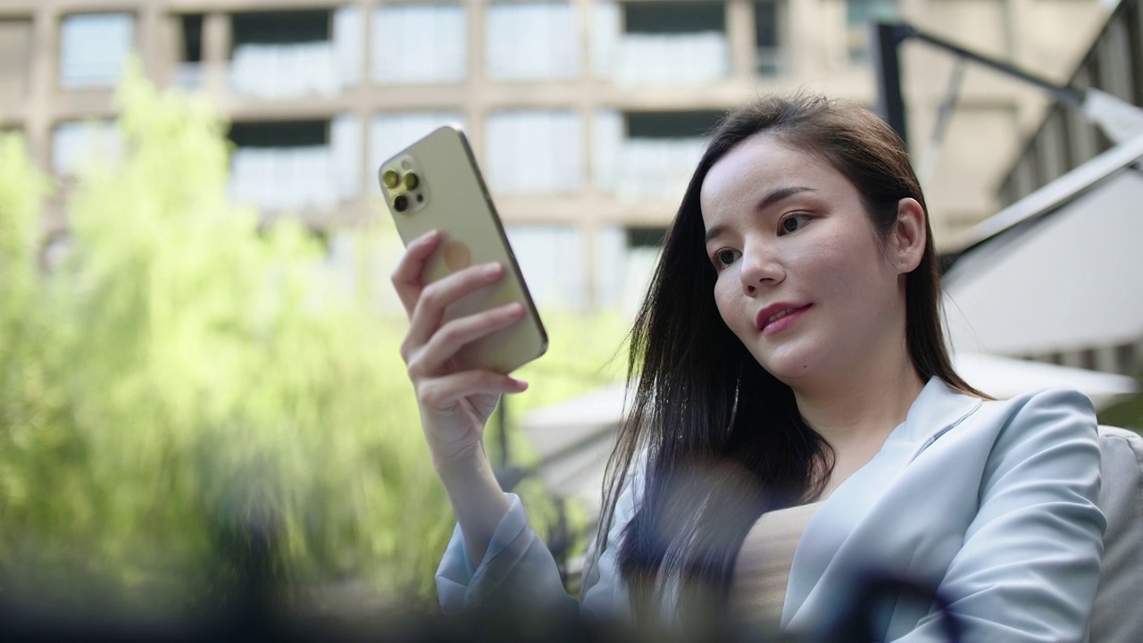 迷人的日本女性在城市街道上使用智能手机视频素材