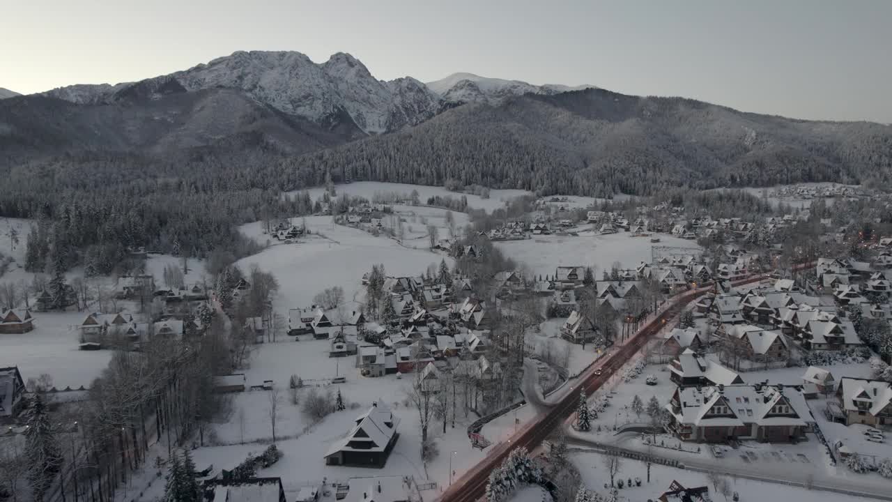 在寒冷的冬季早晨，Zakopane和giewon山的全景。雪中的城市的无人机鸟瞰图视频素材