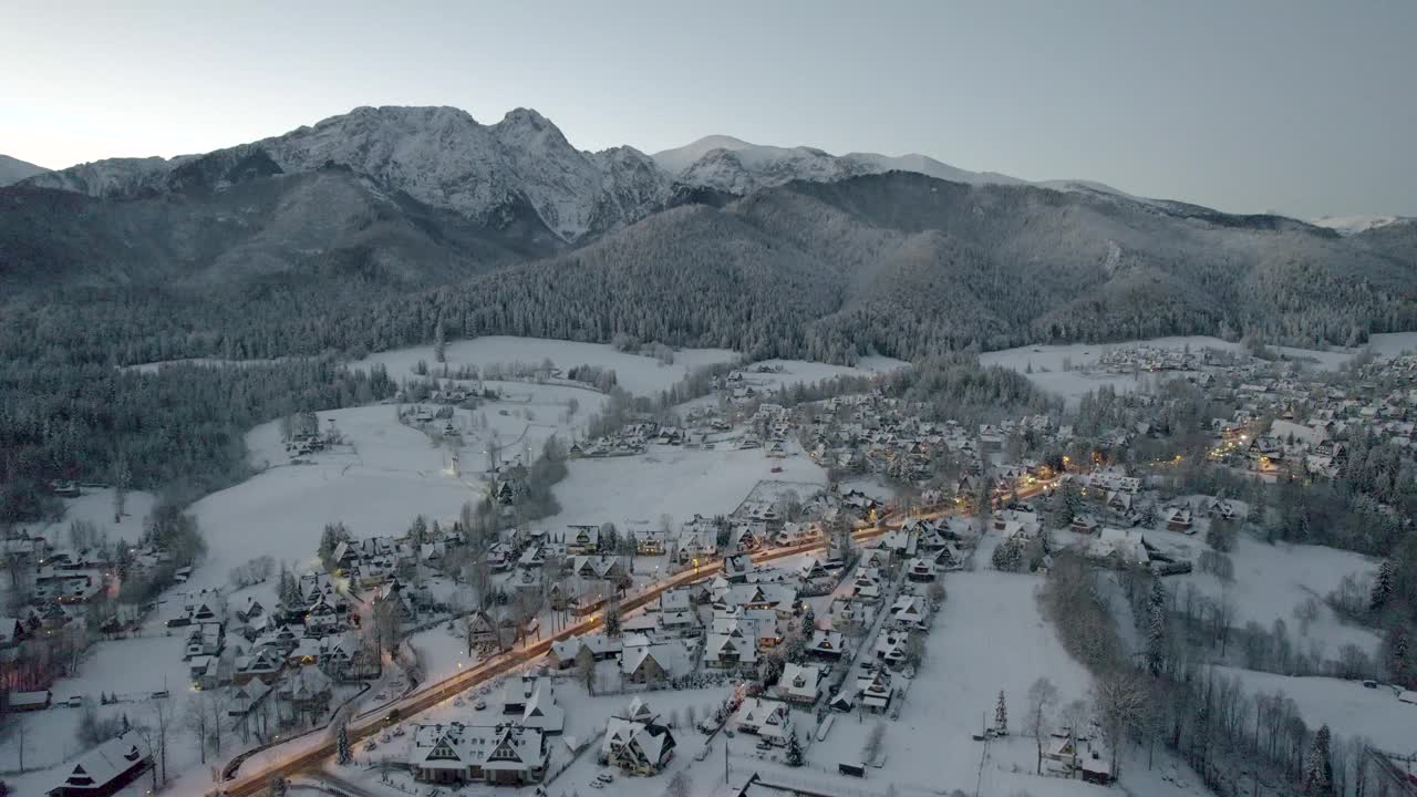 在寒冷的冬季早晨，Zakopane和giewon山的全景。雪中的城市的无人机鸟瞰图视频素材