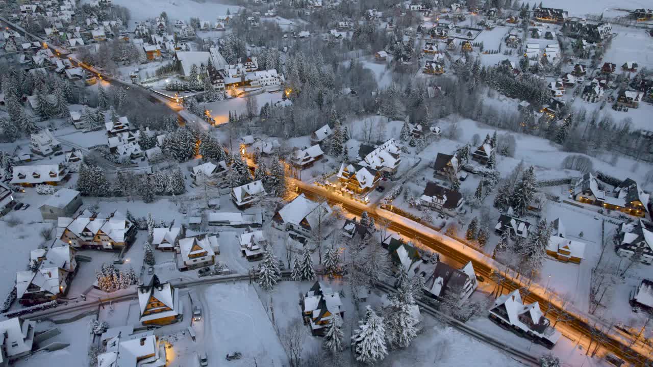 在寒冷的冬季早晨，Zakopane和giewon山的全景。雪中的城市的无人机鸟瞰图视频下载