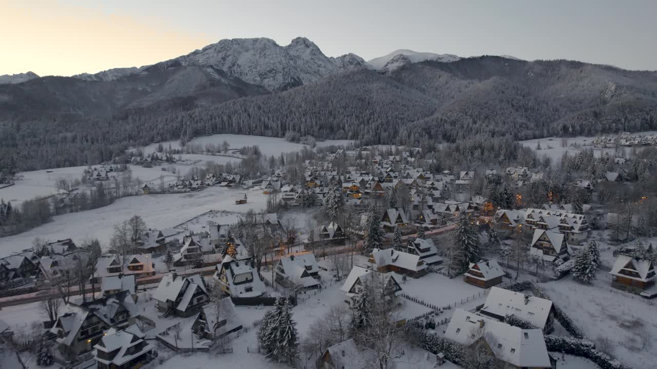 在寒冷的冬季早晨，Zakopane和giewon山的全景。雪中的城市的无人机鸟瞰图视频素材