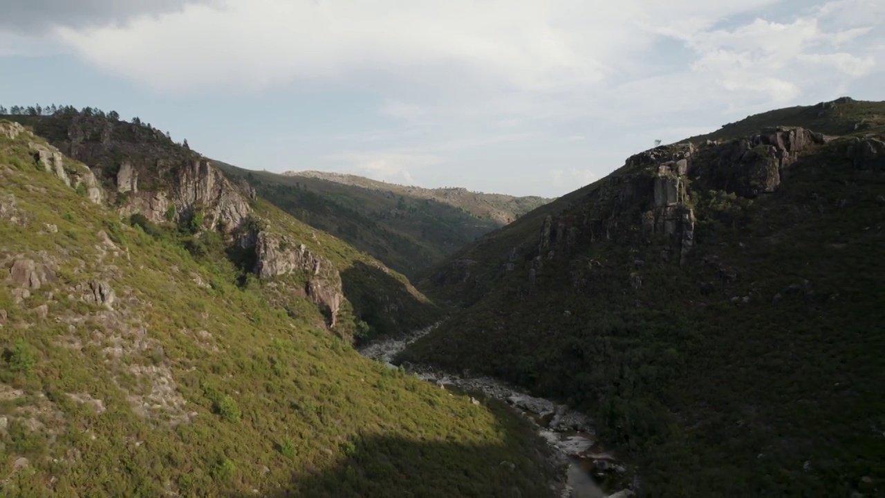 Gerês国家公园郁郁葱葱的群山映衬着多云的蓝天。蜿蜒的河流。空中的回调视频素材