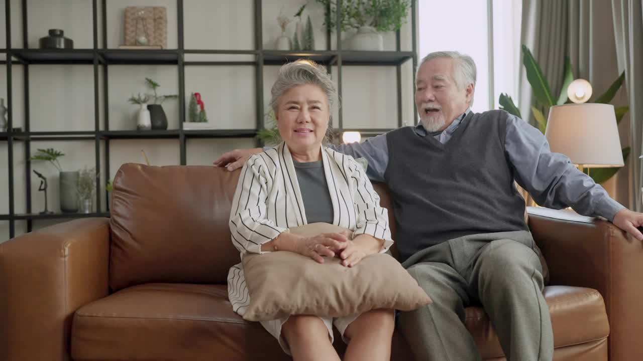 幸福亚洲家庭坦诚的女儿和儿子拥抱祖父母妈妈年长的妈妈舒适放松在沙发沙发惊喜访问在家里的客厅，一起拥抱快乐的亚洲家庭在家里视频素材