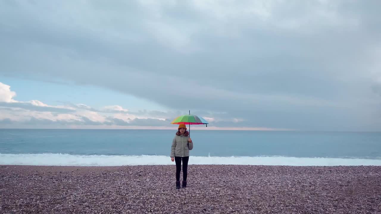 海边拿伞的年轻女子视频素材