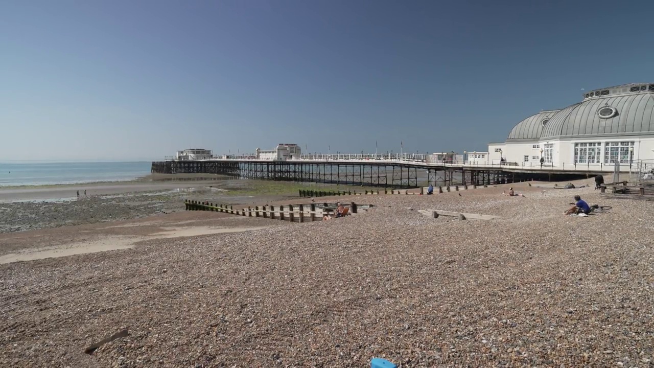 海滩，五颜六色的船和Worthing码头在夏天，Worthing，西苏塞克斯，英格兰，英国，欧洲视频素材