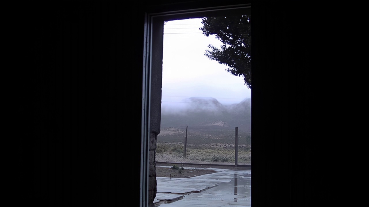 从阿根廷一所乡村学校敞开的门看到的山间雾蒙蒙的雨天早晨。视频素材