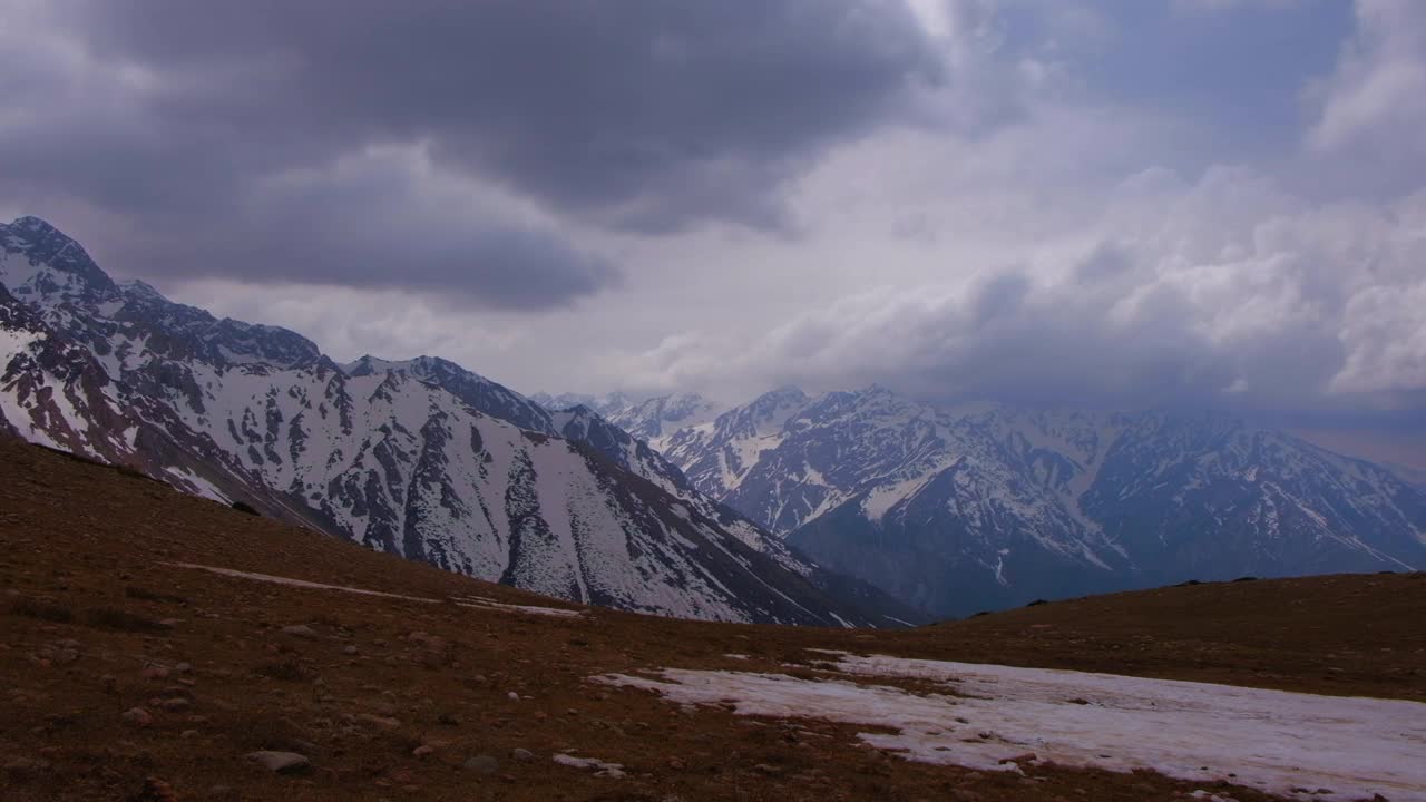 落基山脉被雪覆盖，背景是风暴云。视频下载