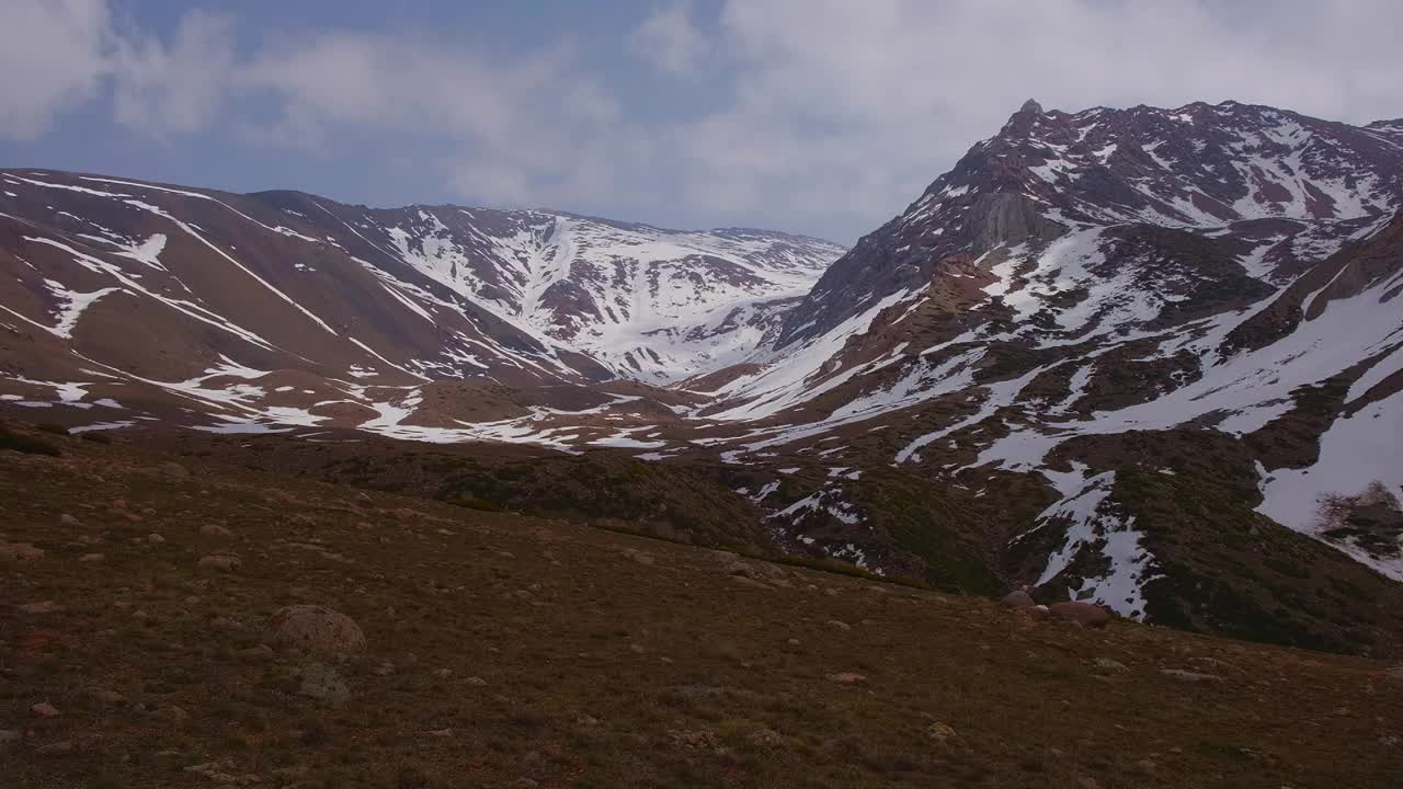 落基山脉被雪覆盖，背景是风暴云。视频下载