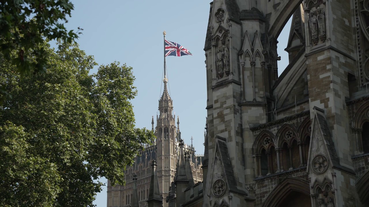 英国，英国，欧洲，伦敦，威斯敏斯特，议会广场维多利亚塔顶部的英国国旗视频素材