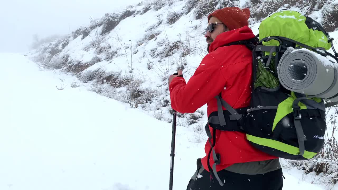 男子登山者站在山顶的山腰上视频素材