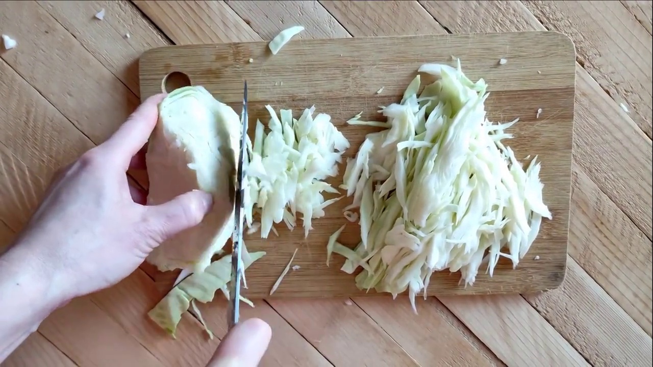 一名女子在切菜板上切卷心菜，第一人称观看视频视频素材