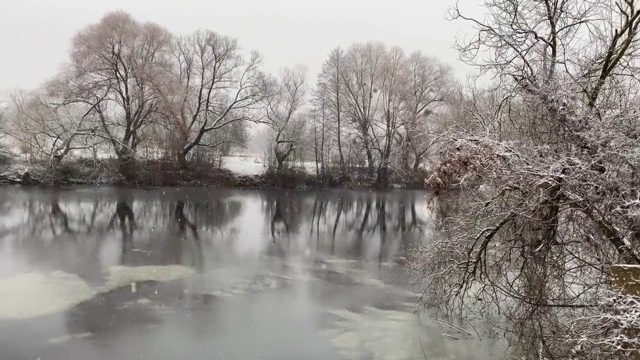 冬天，在树林中间的河流景色优美。雪景视频素材